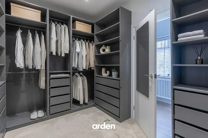 Walk in wardrobe with grey fitted units