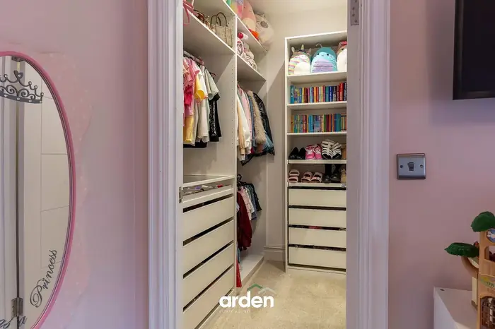 Fitted walk in wardrobe off a childs bedroom