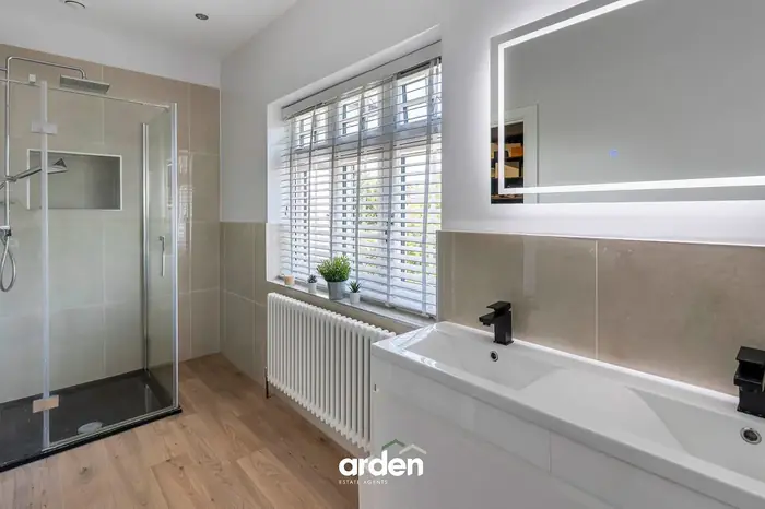 En suite with a walk in shower and a double basin