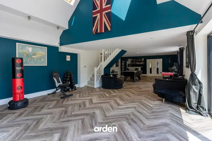 Entertainment wing with gym equipment and a vaulted ceiling