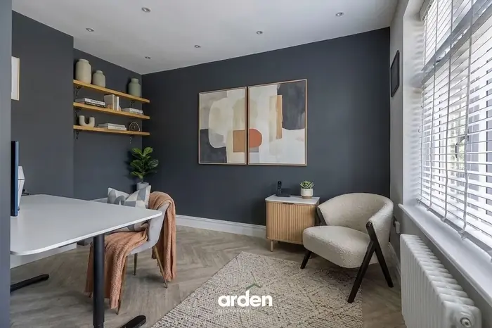 Home office with a navy feature wall and floating shelves