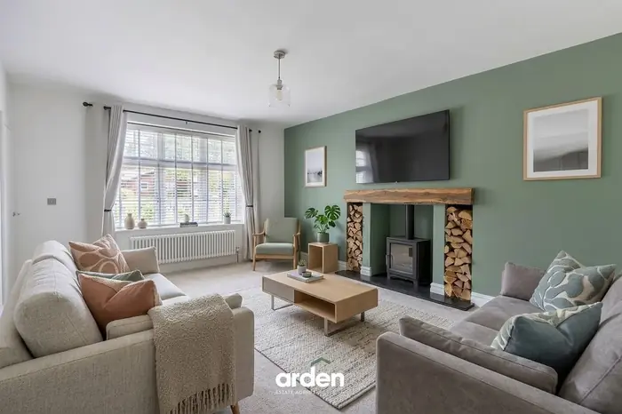 Snug with a log burner and a green feature wall